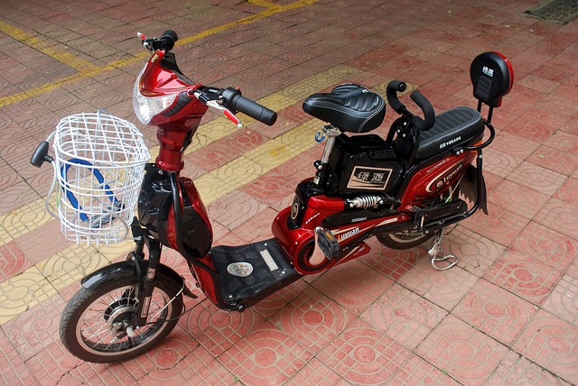 An image of a person riding an electric motorcycle on a city street, passing a traffic sign displaying a motorcycle icon with a red line across it